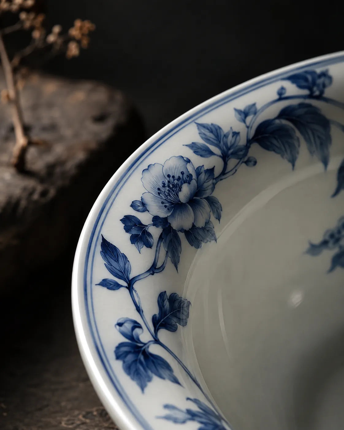 Close-up of cobalt floral decoration along a white porcelain rim.